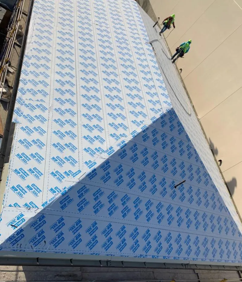 Professional roofers installing underlayment on a metal roof in Frankfort